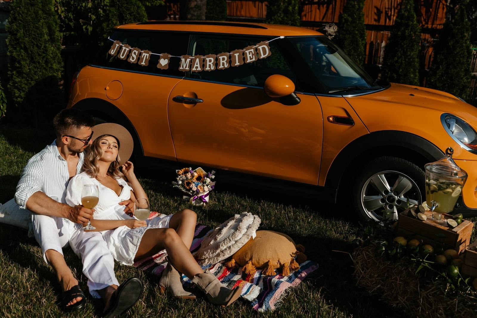 Cuplu la picnic lângă mașina decorată Just Married